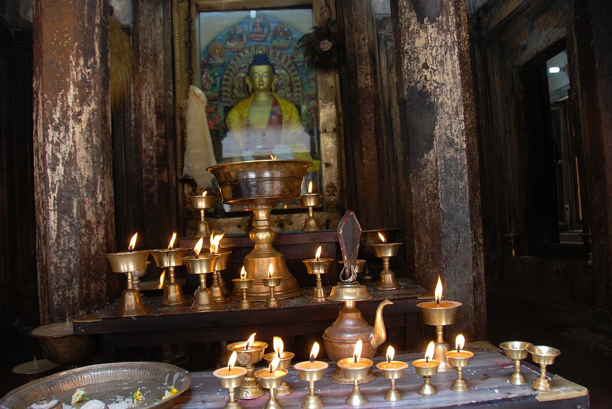 Kathmandu Patan 06 Mahabouddha Temple 04 Buddha Statue Flickering butter lamps and offerings frame a golden coloured statue of Buddha inside the Mahabouddha Temple in Patan.